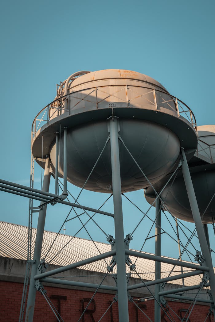Close-up view of an industrial water tank against a clear blue sky.