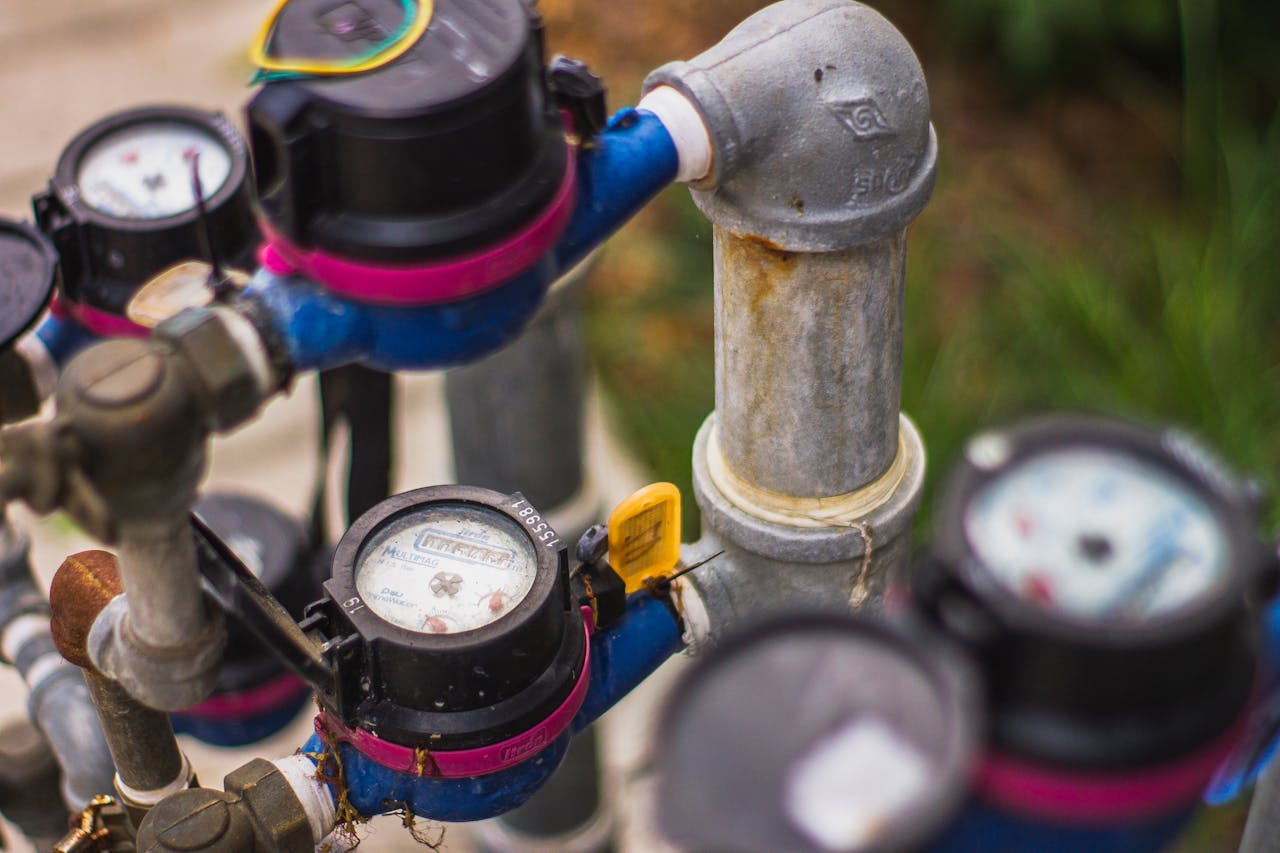 services-02 Detailed image of industrial water pressure gauges and pipes in an outdoor setting.